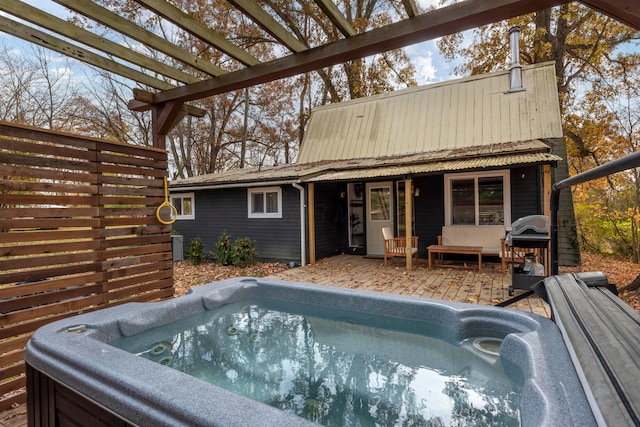 exterior space with a pergola and a hot tub