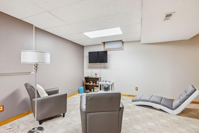 living room featuring a paneled ceiling and carpet