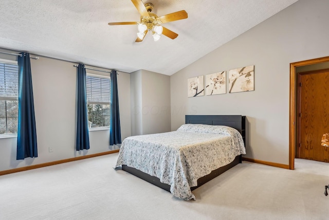 bedroom with vaulted ceiling, ceiling fan, carpet floors, and a textured ceiling