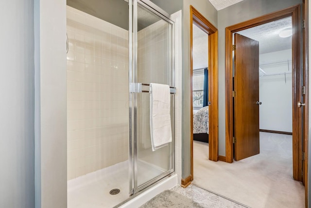 bathroom featuring a shower with shower door and a textured ceiling