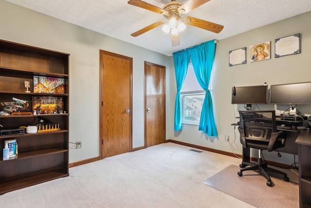 home office featuring ceiling fan, light carpet, and a textured ceiling