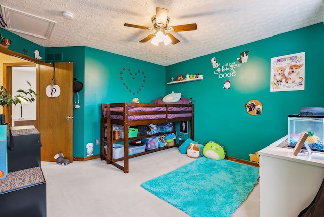 carpeted bedroom with ceiling fan and a textured ceiling