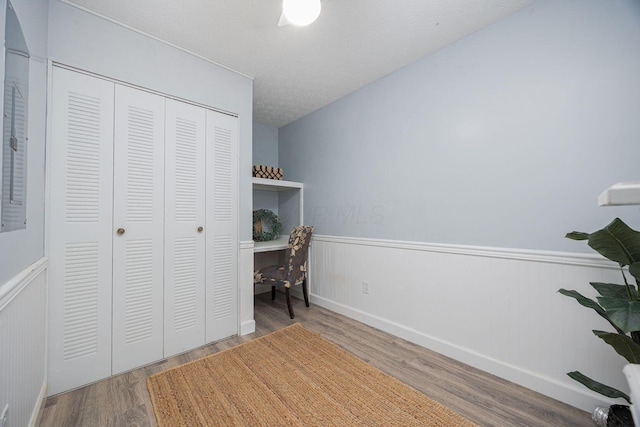 unfurnished office featuring hardwood / wood-style floors and a textured ceiling