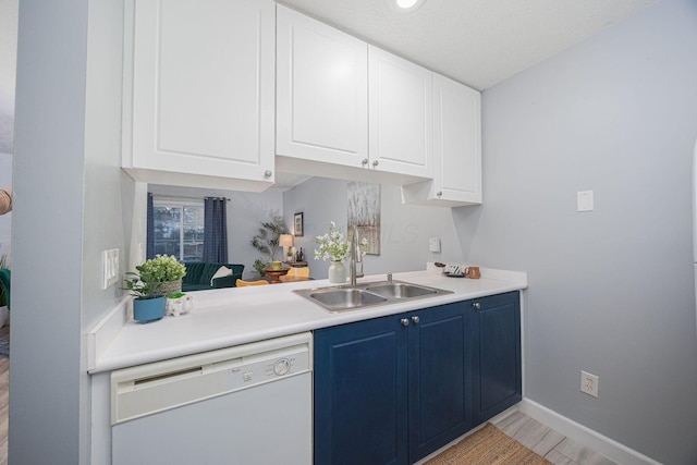 kitchen with dishwasher, sink, light wood-type flooring, blue cabinetry, and white cabinetry