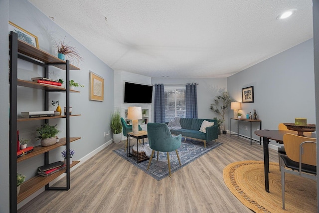 living room with light hardwood / wood-style floors and a textured ceiling