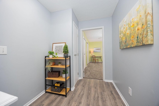 corridor featuring dark hardwood / wood-style flooring and a textured ceiling