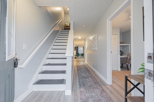 stairway featuring hardwood / wood-style floors and a textured ceiling