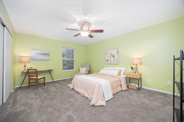 bedroom featuring dark colored carpet, a textured ceiling, a closet, and ceiling fan