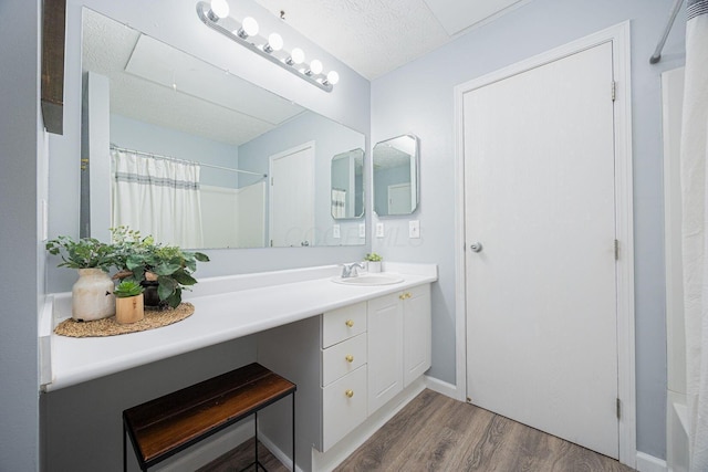 bathroom featuring hardwood / wood-style flooring, vanity, shower / bathtub combination with curtain, and a textured ceiling