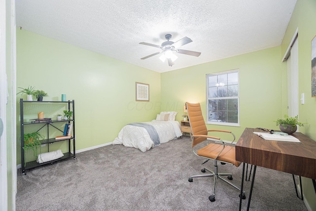 carpeted bedroom featuring ceiling fan and a textured ceiling