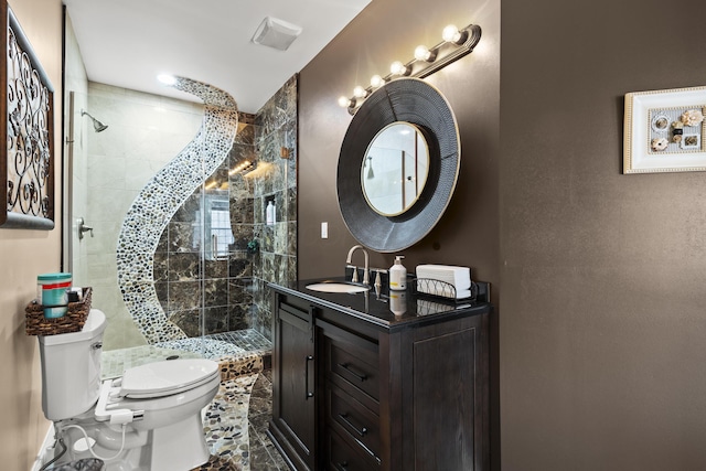 bathroom with a shower with door, vanity, and toilet