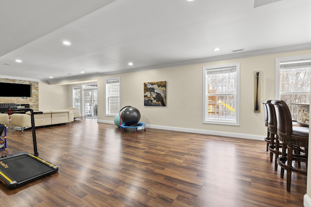 exercise room with dark hardwood / wood-style flooring and ornamental molding