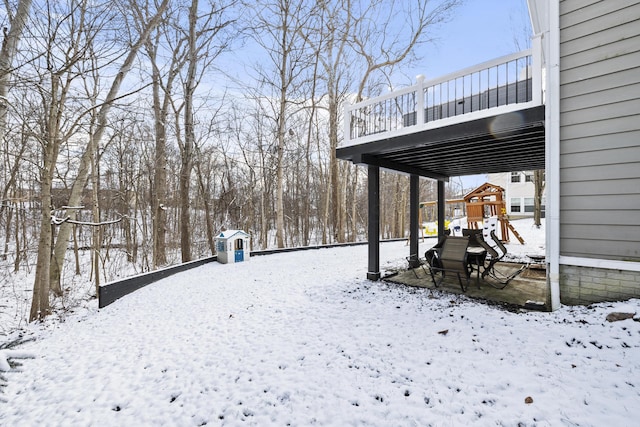 snowy yard featuring a playground