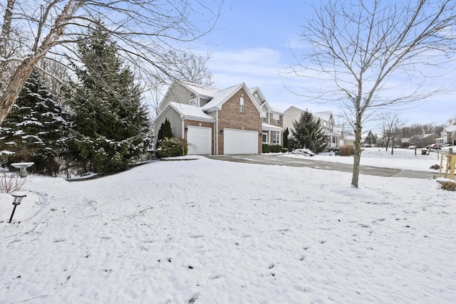 snow covered property with a garage