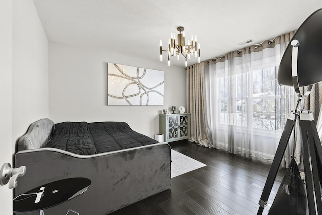 bedroom featuring dark hardwood / wood-style flooring and a chandelier