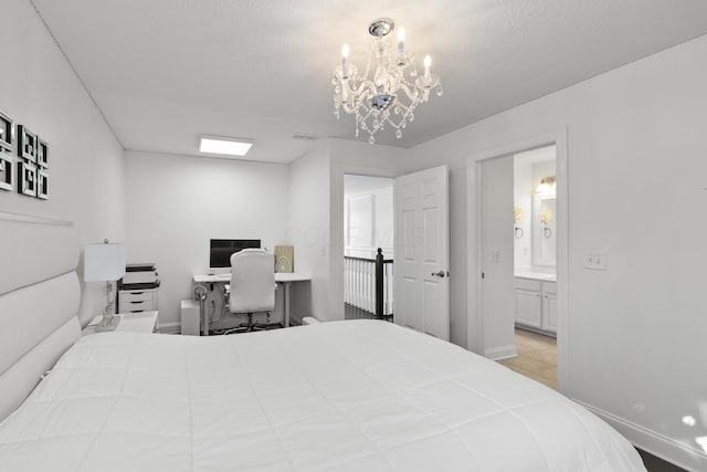 bedroom with ensuite bathroom, a textured ceiling, and an inviting chandelier