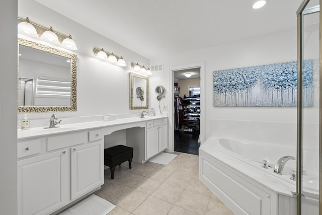 bathroom with tile patterned flooring, vanity, and a tub