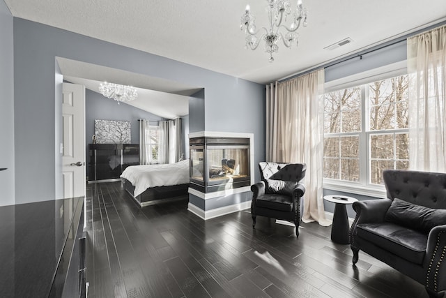 bedroom featuring a chandelier, vaulted ceiling, multiple windows, and dark wood-type flooring