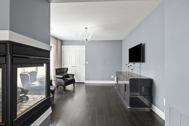 interior space featuring dark wood-type flooring, a chandelier, and a textured ceiling