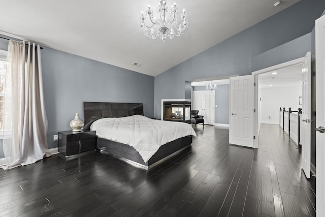 bedroom featuring a multi sided fireplace, high vaulted ceiling, a chandelier, and dark hardwood / wood-style floors