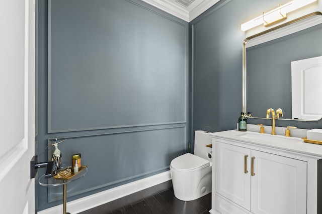 bathroom with crown molding, vanity, and toilet