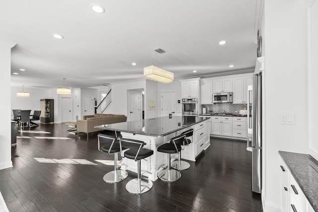 kitchen featuring white cabinets, pendant lighting, stainless steel appliances, and a kitchen island