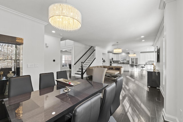 dining room with a healthy amount of sunlight, ornamental molding, and a notable chandelier