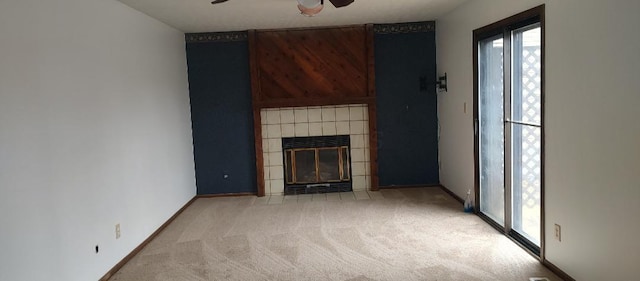 unfurnished living room with ceiling fan, light carpet, and a tile fireplace