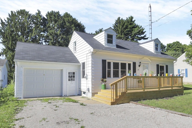 cape cod house featuring a deck and a garage