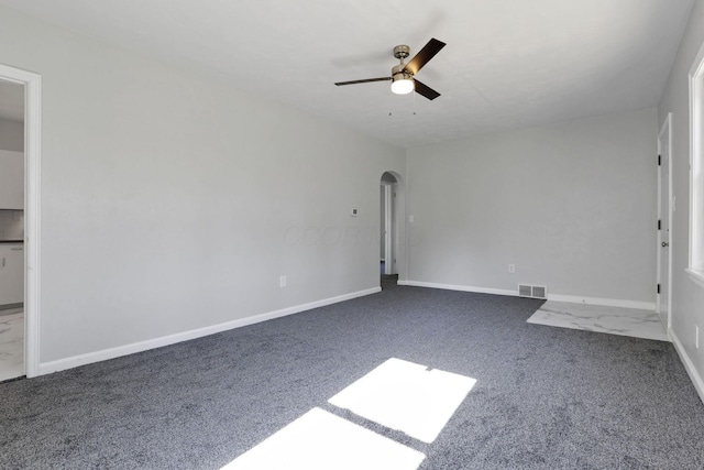 unfurnished room featuring dark carpet and ceiling fan