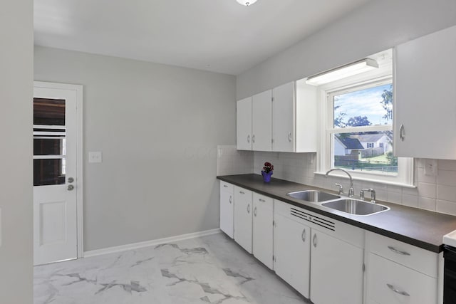 kitchen with white cabinets, sink, and tasteful backsplash