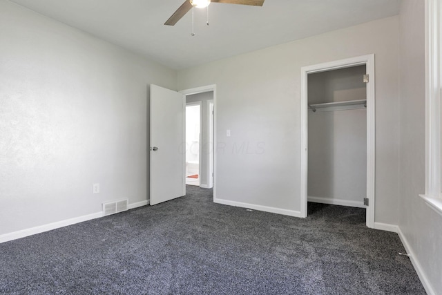 unfurnished bedroom with a closet, dark carpet, and ceiling fan