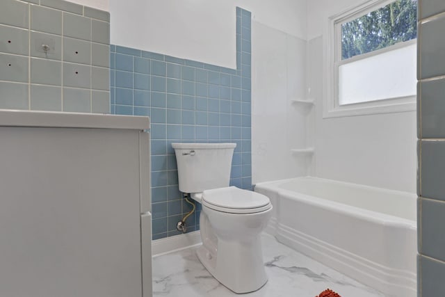 bathroom featuring tile walls and toilet