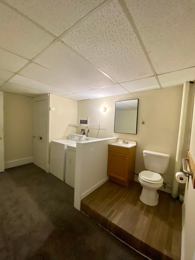 bathroom featuring a drop ceiling, toilet, independent washer and dryer, and vanity