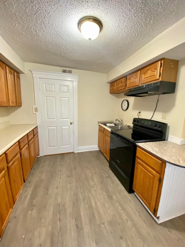 kitchen with a textured ceiling, light wood-type flooring, black / electric stove, and sink