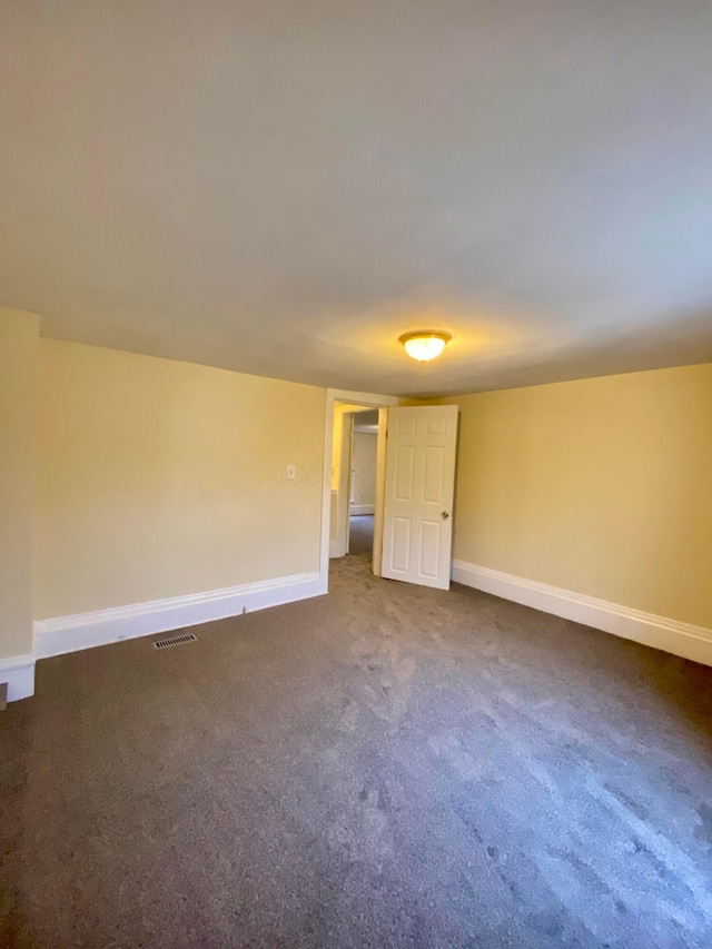 unfurnished room with dark carpet