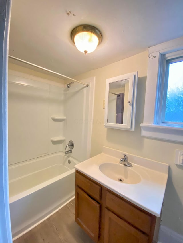 bathroom featuring hardwood / wood-style flooring, vanity, and  shower combination