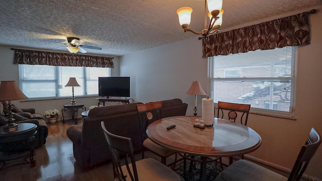 dining room featuring a textured ceiling, ceiling fan with notable chandelier, and hardwood / wood-style flooring