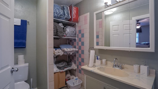 bathroom featuring vanity, ceiling fan, and toilet