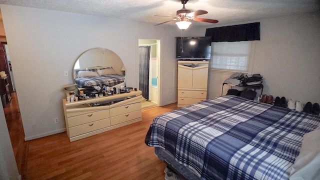 bedroom with a textured ceiling, light hardwood / wood-style floors, and ceiling fan