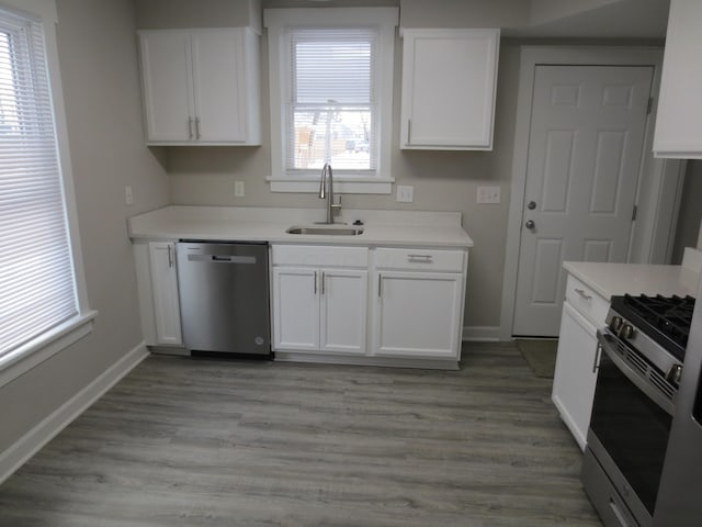 kitchen with stainless steel appliances, white cabinetry, plenty of natural light, and sink