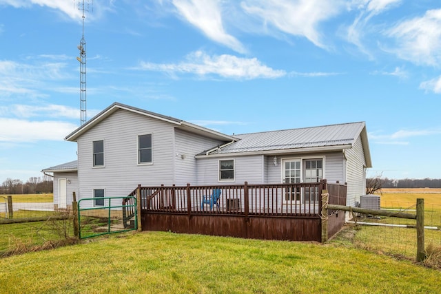 rear view of property featuring a lawn, cooling unit, and a deck