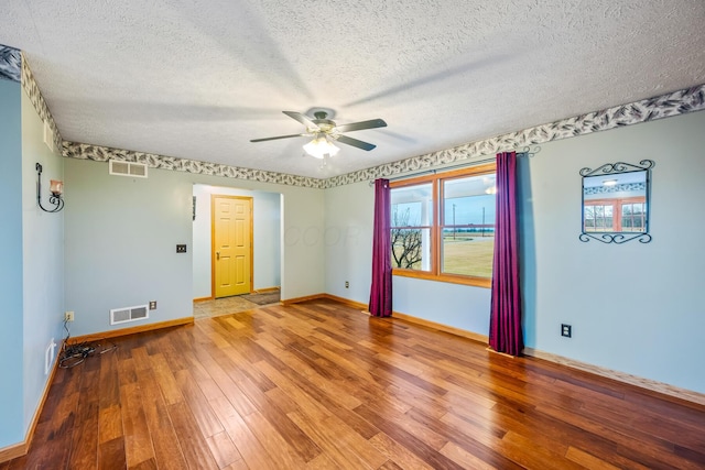 unfurnished room with hardwood / wood-style flooring, ceiling fan, and a textured ceiling