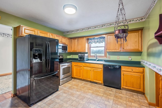 kitchen featuring sink, black appliances, and decorative light fixtures