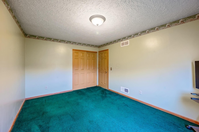 unfurnished bedroom featuring carpet floors, a textured ceiling, and a closet