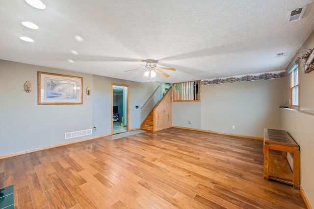 empty room with a textured ceiling, light hardwood / wood-style flooring, and ceiling fan