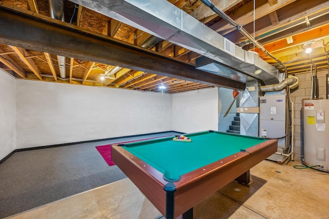 recreation room featuring heating unit, electric water heater, pool table, and concrete flooring