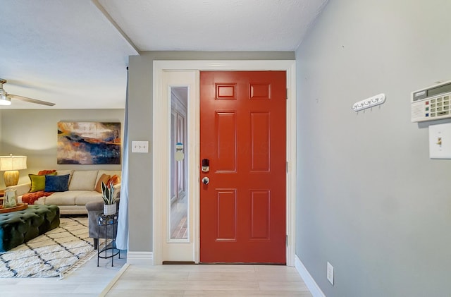 foyer entrance with ceiling fan and light hardwood / wood-style flooring