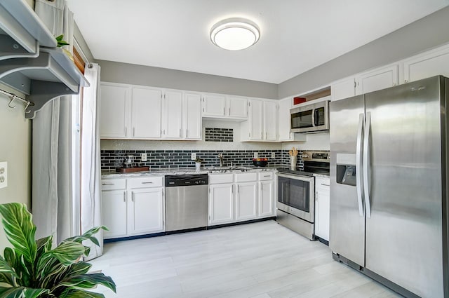 kitchen featuring backsplash, sink, white cabinetry, and stainless steel appliances