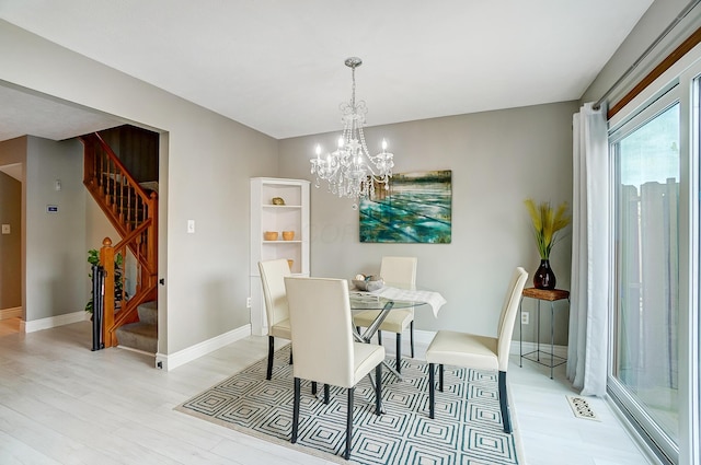 dining room with light hardwood / wood-style flooring and a notable chandelier